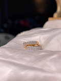 Gold-plated Xuping mini hoop earrings featuring rows of sparkling clear stones along the front, displayed on soft beige fabric.